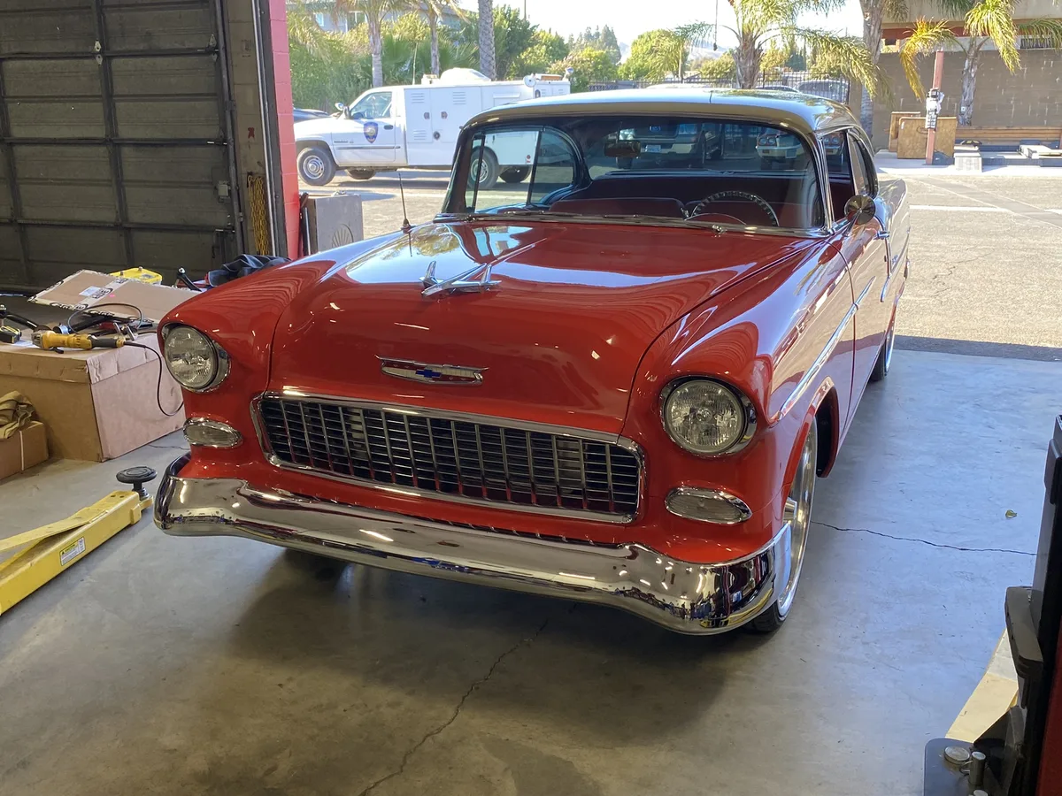 Red and cream classic sedan with chrome details at shop